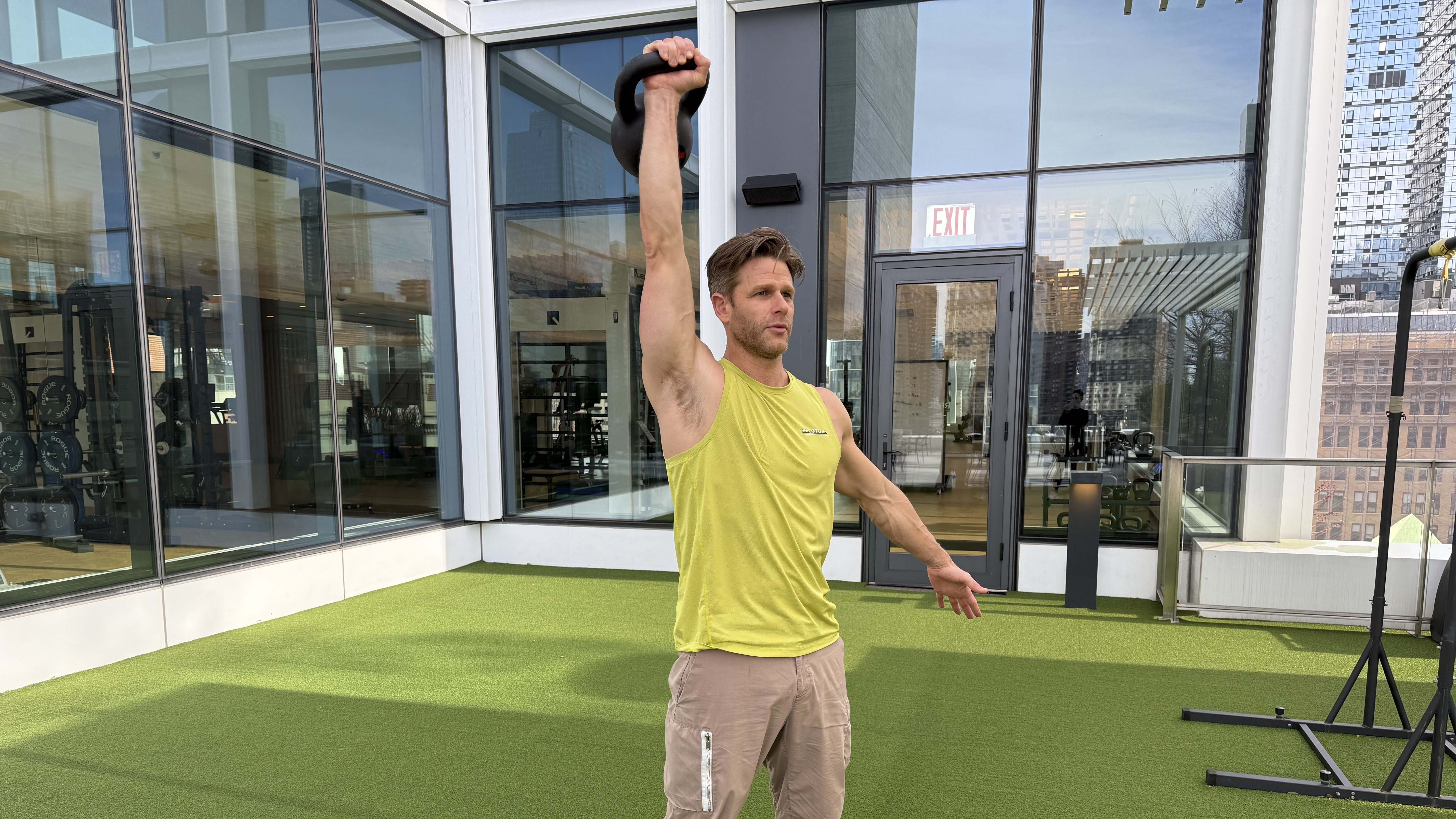 a photo of Peloton trainer Andy Speer doing a kettlebell single-arm press