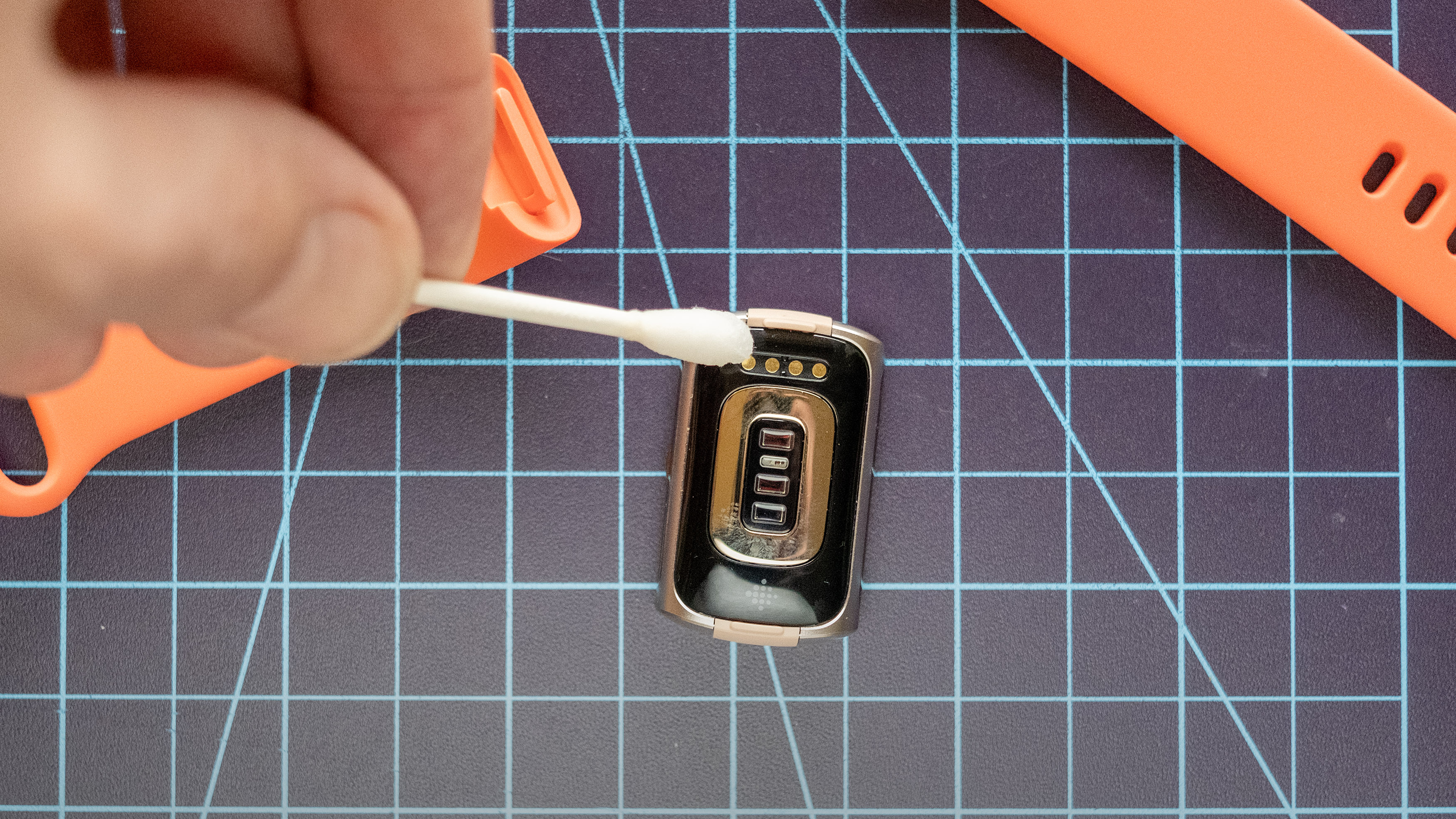 تنظيف نقاط الاتصال الكهربائية في جهاز Fitbit Charge 6.