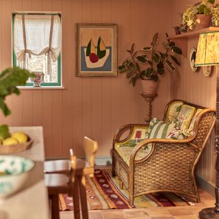 Italian inspired kitchen with cosy seating area with wicker armchair abstract artwork and houseplant