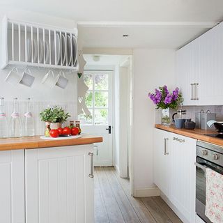 kitchen with white wall white cabinet and wooden counter