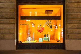 Window display showing glass lighting and interior objects