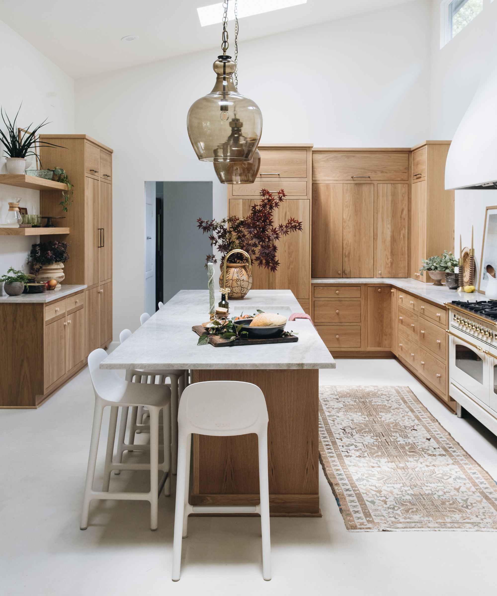 A kitchen with wooden cabinets and marble countertops