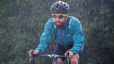 Image shows a rider cycling in the rain.