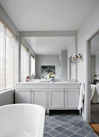 grey bathroom with large mirror and dark grey stone floors