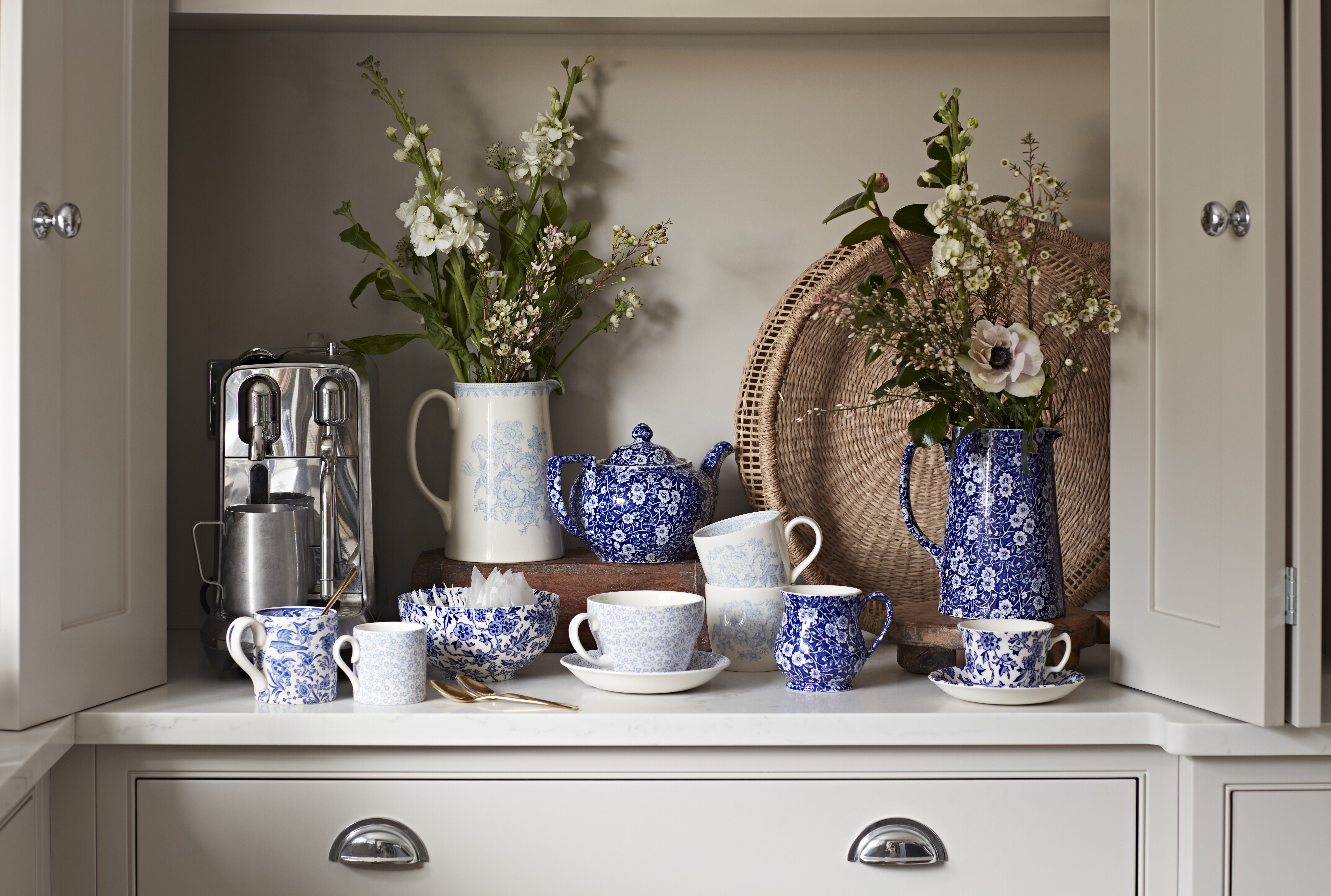 A collection of blue and white pottery displayed in a kitchen cabinet