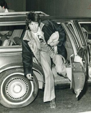 Keith Richards getting out of his car after court appearance in 1977