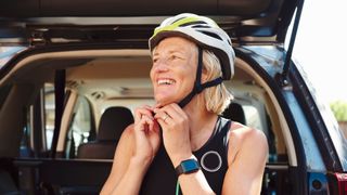 woman strapping a bike helmet onto her head