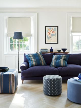 Navy blue living room soft furnishings with white walls and parquet white-wash wooden flooring