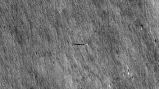 A dark streak over the moon as seen by a NASA spacecraft.