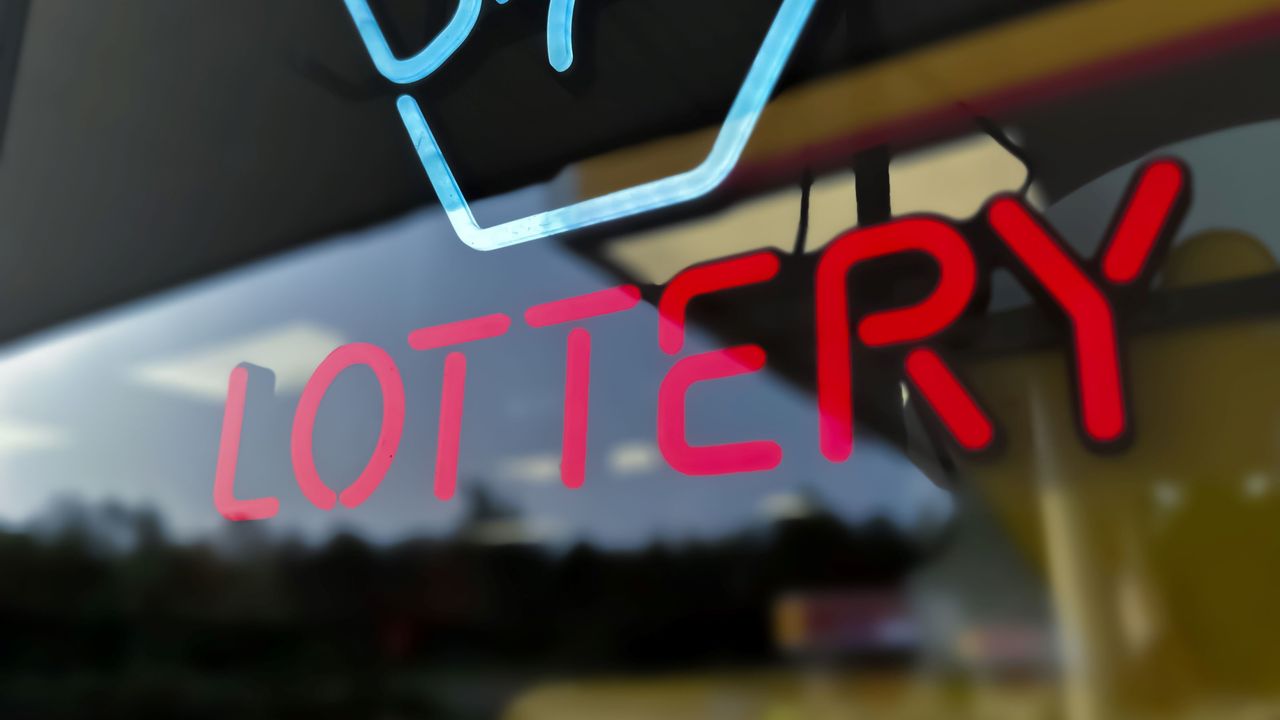 A neon sign in a window that says &quot;lottery.&quot;