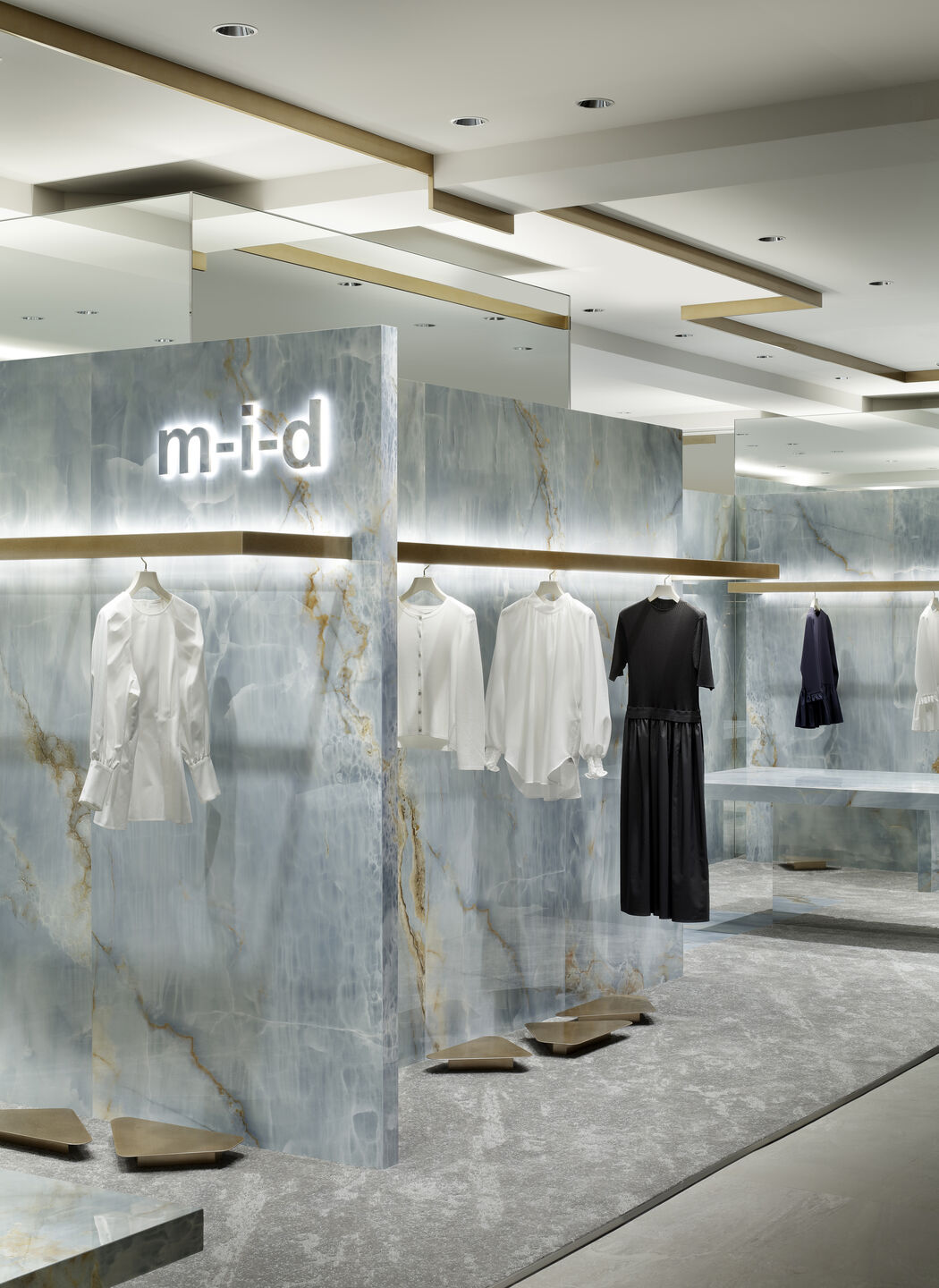 An onyx, chrome, and mirror-clad fashion boutique boasts back-lit product hangers and a slightly utopian atmosphere.