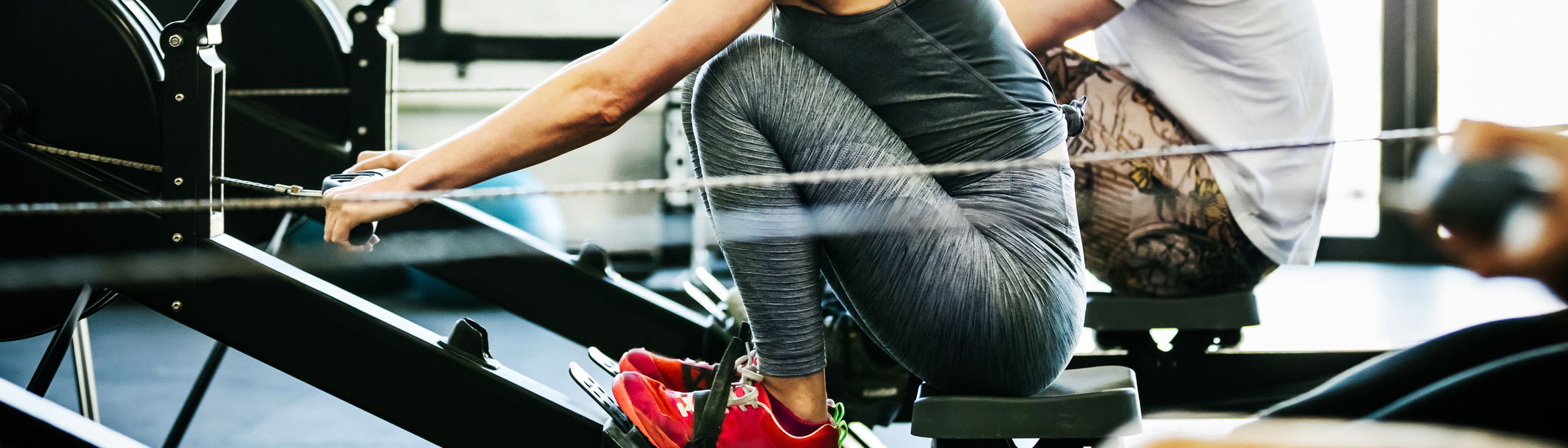 A close-up picture of people working out on rowing machines