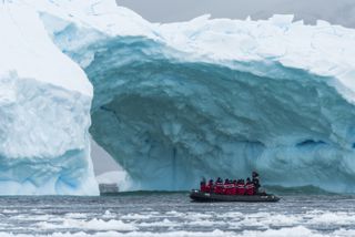 Travelers on a Zodiac boat go through the ice in Antarctica