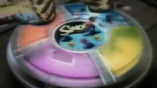 A Simon board is hit by cartoon hands.