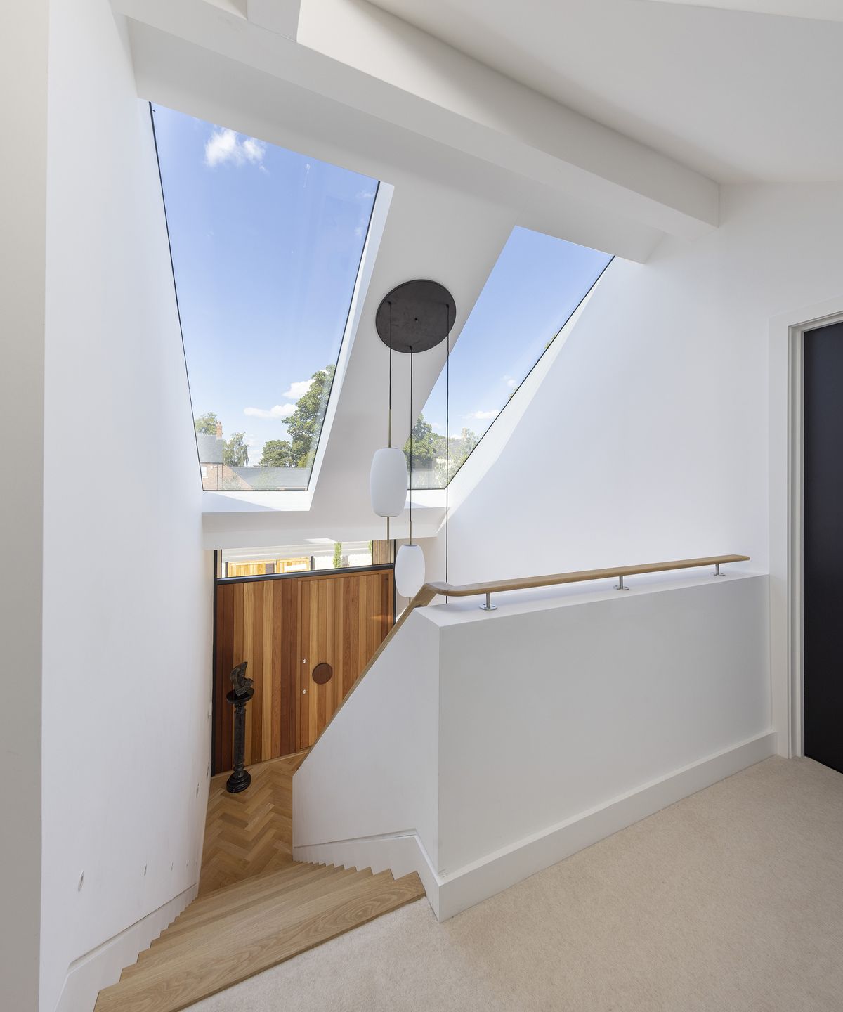 view down stairs from a first floor loft extension of a bungalow with large glazing