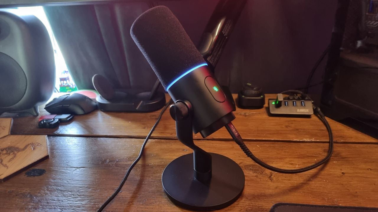 A Razer Seiren V3 Pro streaming microphone on a wooden desk