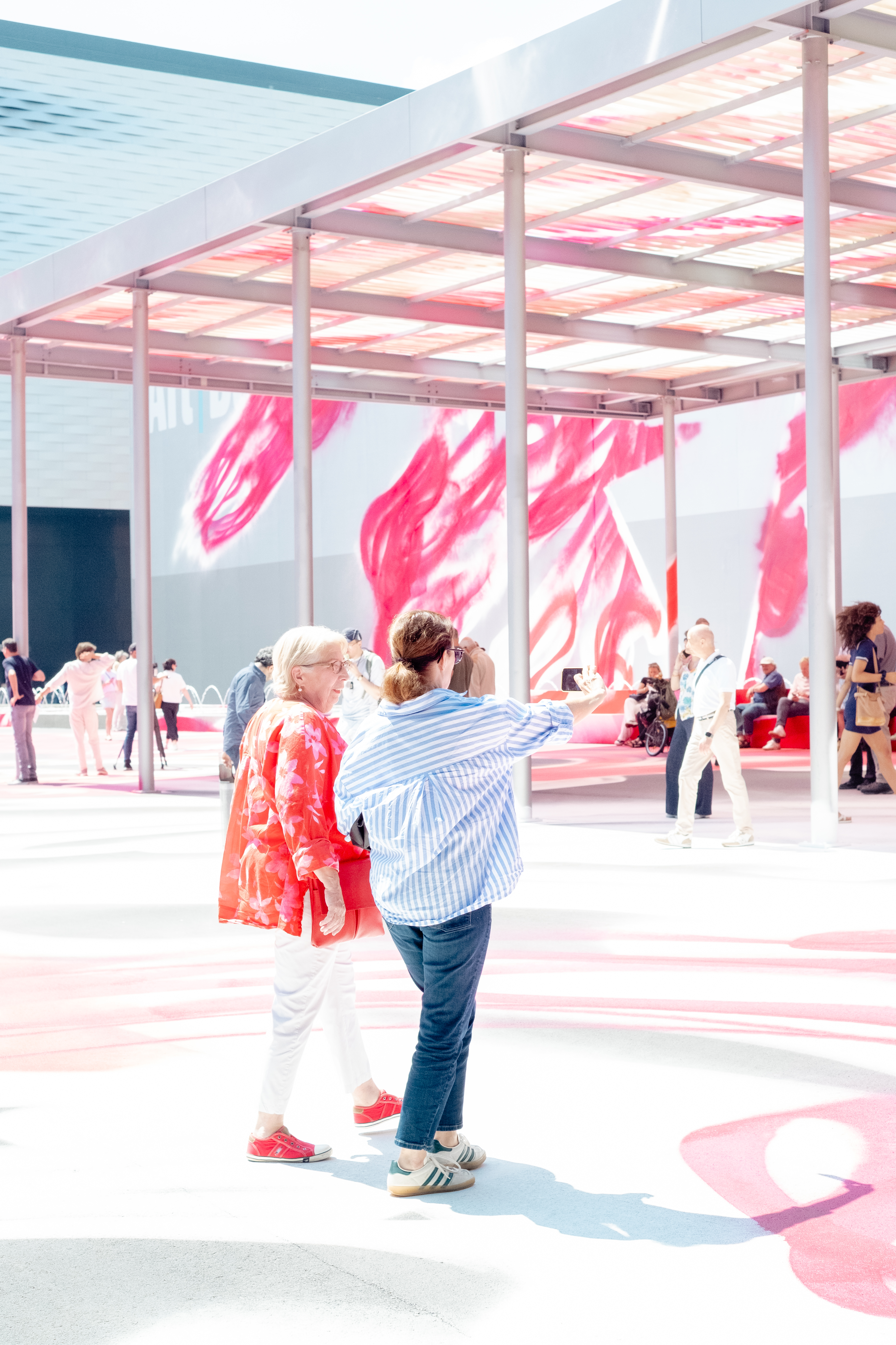 People are photographed out in the sunshine in a Swiss town characterized by beautiful architecture, lush greenery, and art installations.