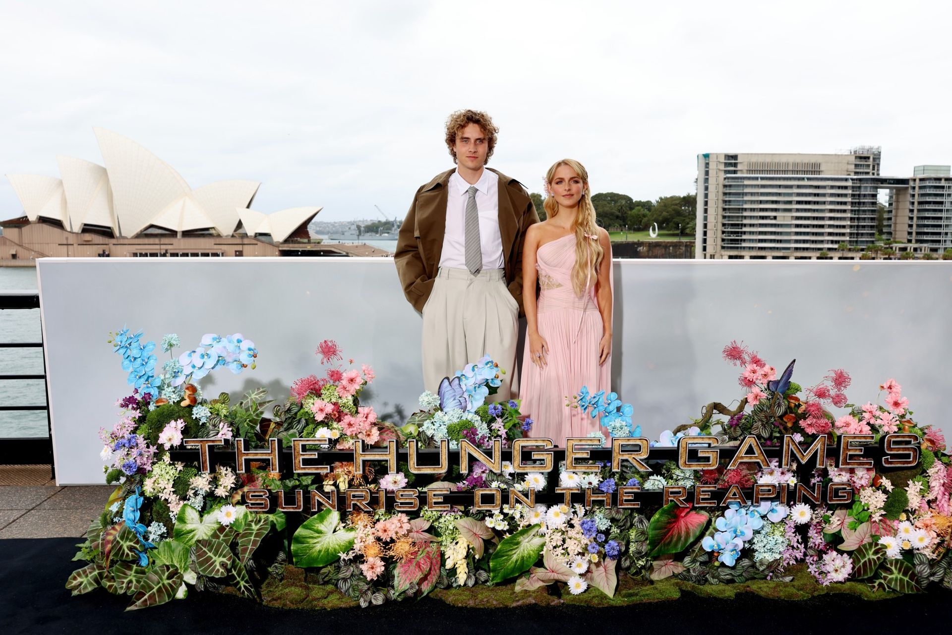 Joseph Zada wearing a suit and Mckenna Grace wearing a pink dress as they arrive for a photo call for 