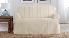 Amazon slipcover sofa in cream pinestripe pictured in a white living room with wooden side tables
