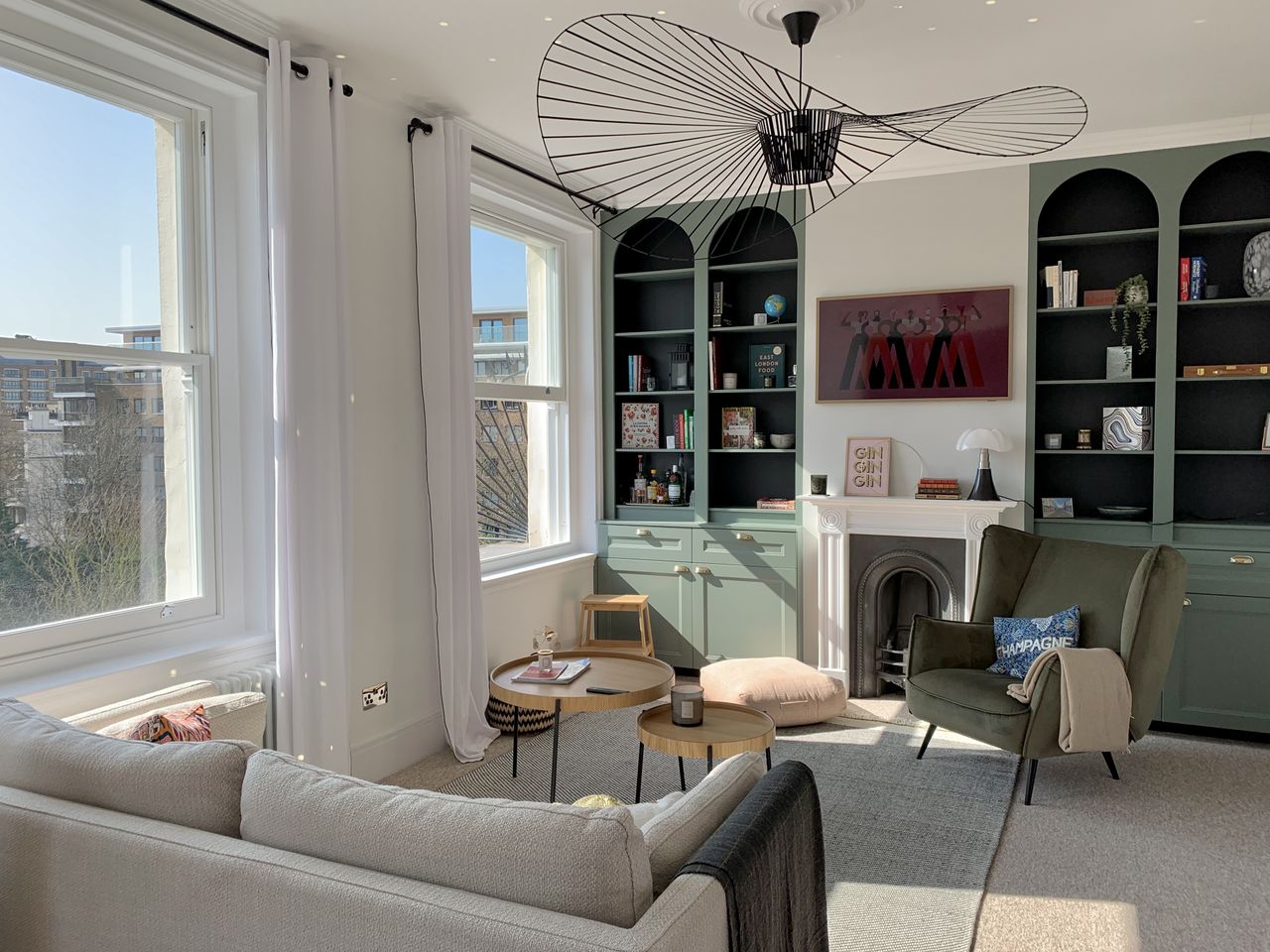 A living room with arched alcove shelving, a sofa and large windows