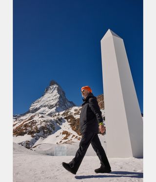 Man walks past obelisk in snow, part of Daniel Arsham Hublot installation