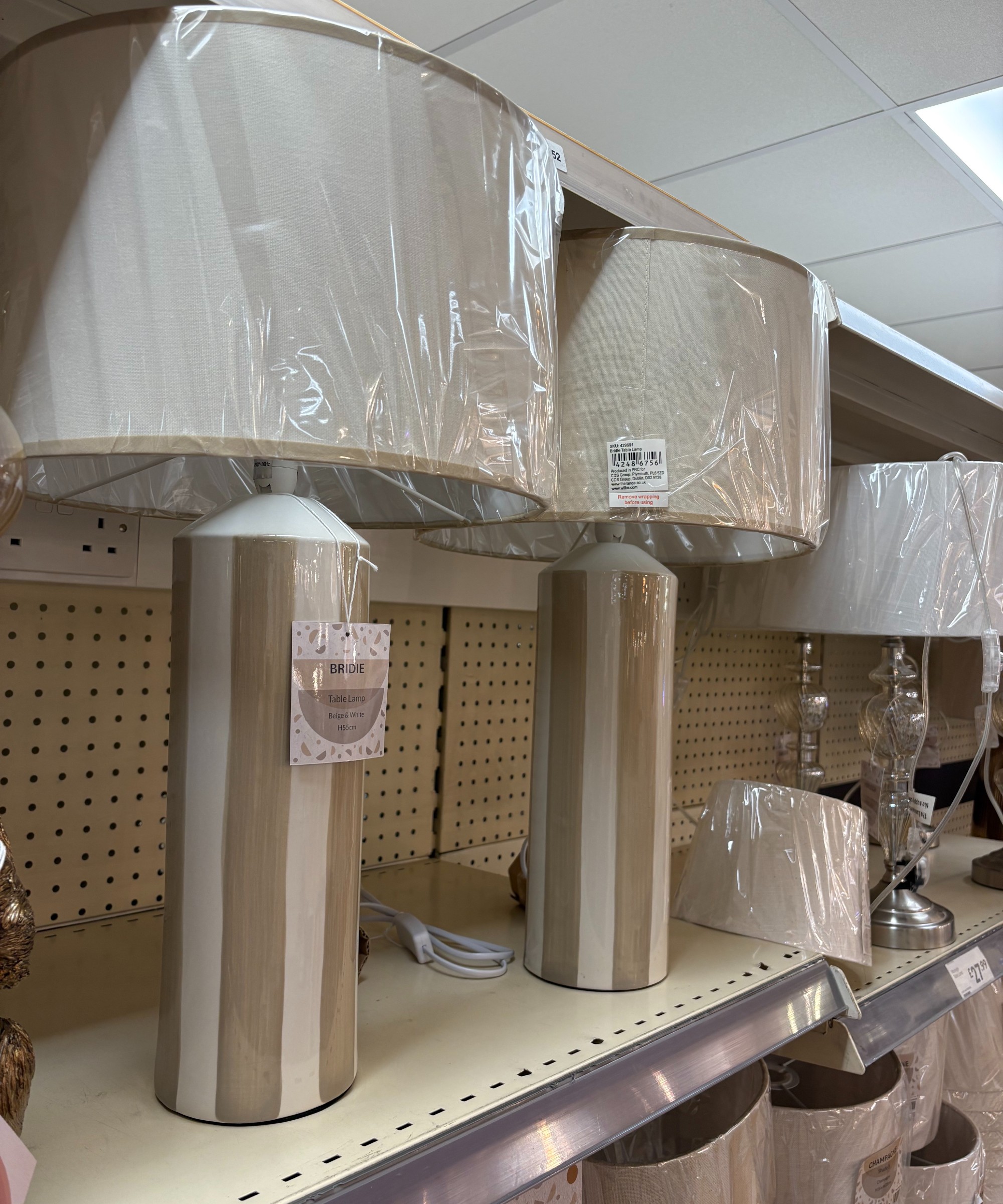 Striped table lamps displayed on a shelf in The Range store