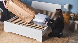 Two women unbox a Helix mattress after leaving it in its box for too long, which is a common mistake people make after buying a new mattress