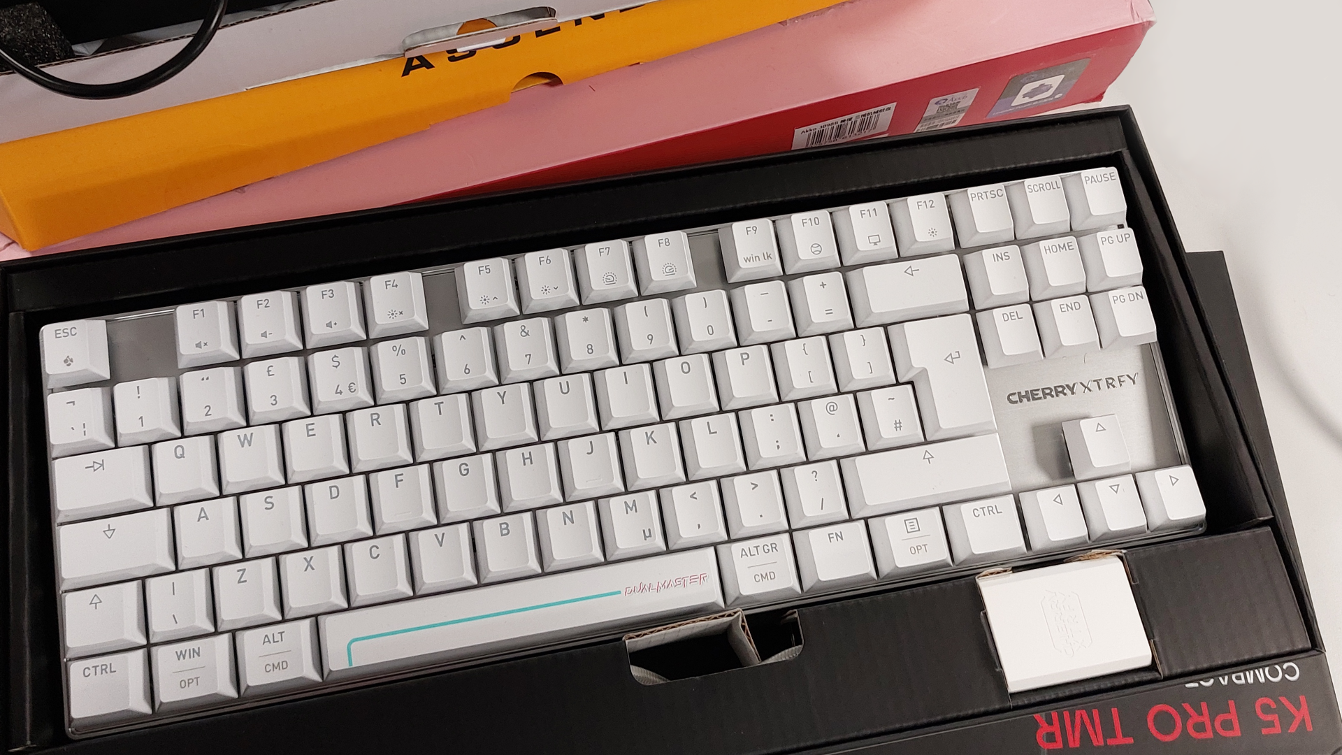 A photograph of a gaming keyboard on a wooden desk.