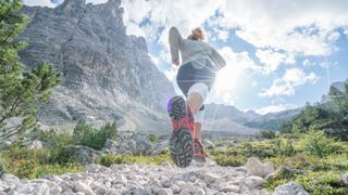 A woman trail running in the mountains