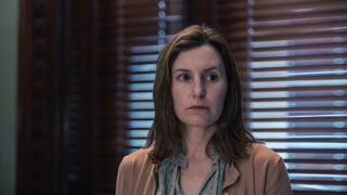 Laura Carmichael in a beige jacket and green shirt in front of a window in court as Agatha Fyfle in The Secrets She Keeps.
