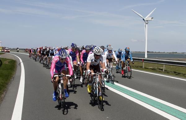 The chasing peloton works hard into the wind to regain the lead group.