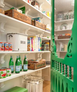 A walk-in pantry with green accents and soda storage crates