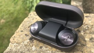 the beoplay eq true wireless earbuds in their charging case