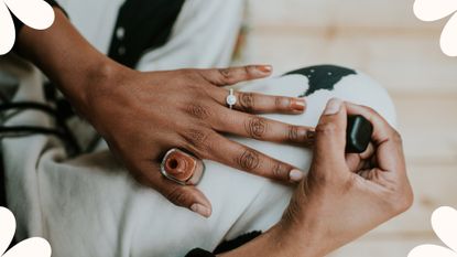 close up of woman's hands painting her own nails, using a gel manicure alternative - nail varnish