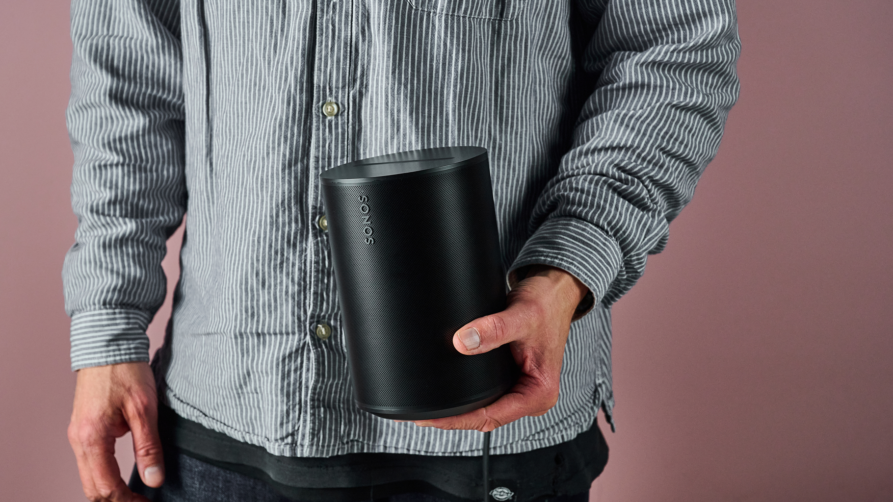 A man holding the Sonos Era 100 SL from beneath.