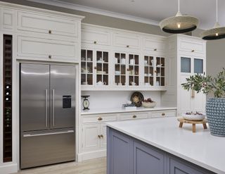 kitchen with large american stainless steel fridge and traditional white cabinets