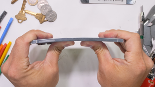 Galaxy S25 Edge durability test by JerryRigEverything, with the phone being bent from the back without damage