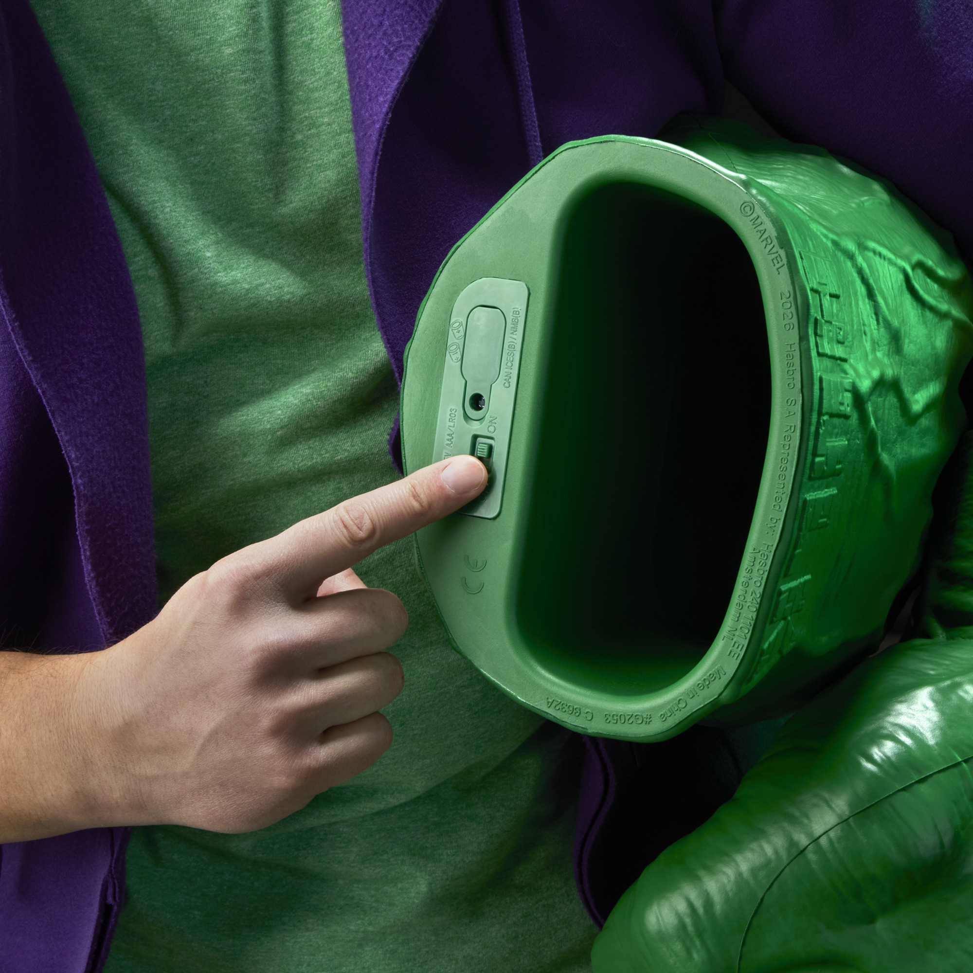 A roaring man with two Hulk Fists pretends to punch with them against a black background
