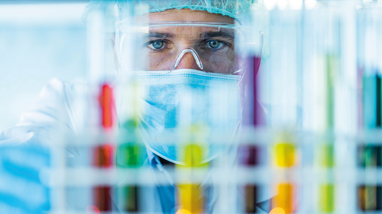 Scientist examining test tubes ©Getty Images