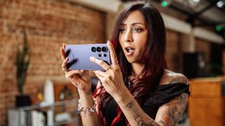 A woman holding a Samsung Galaxy S26 Ultra with both hands.