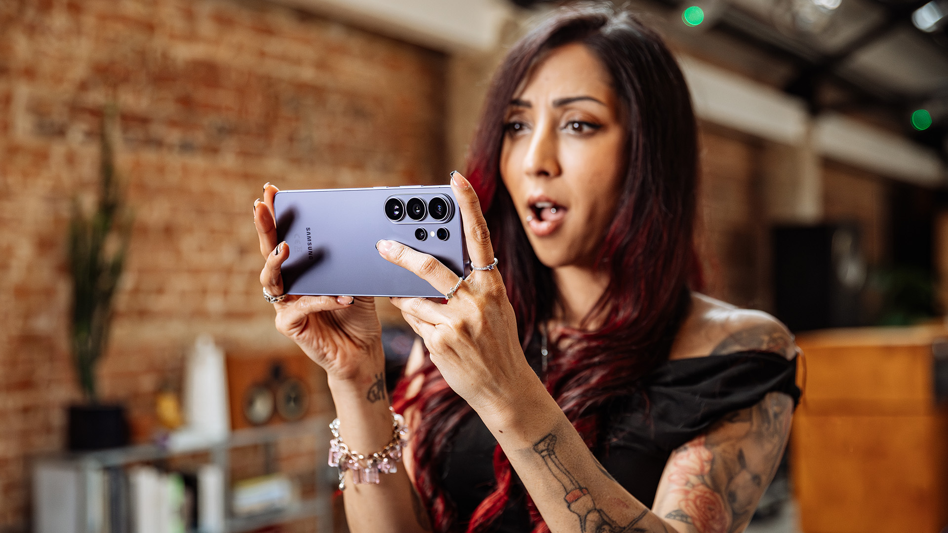 A woman holding a Samsung Galaxy S26 Ultra with both hands.