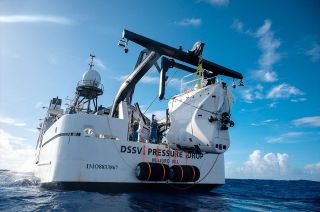 Caladan Oceanic's DSV Limiting Factor submersible hangs off the back of its mothership, the DSSV Pressure Drop, between dives to Challenger Deep in June 2020.