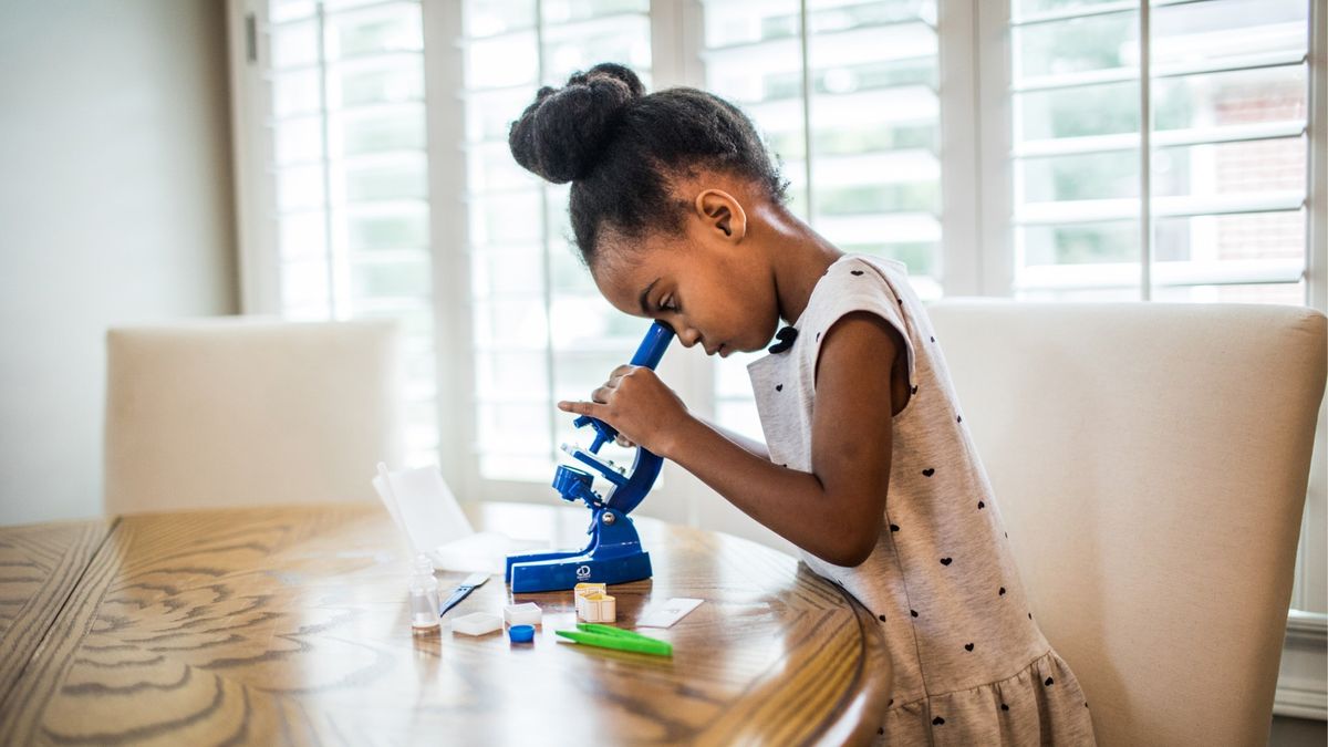 girl using a microscope in the home