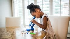 girl using a microscope in the home