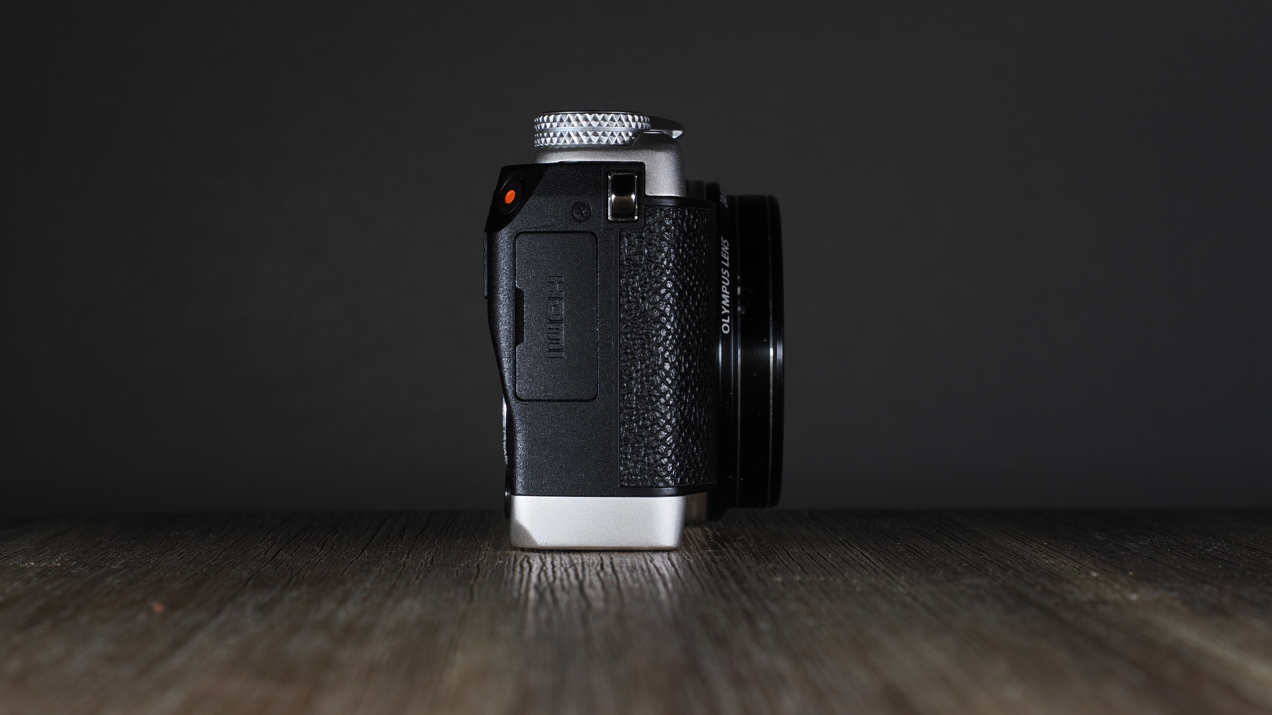 Olympus Stylus SH-3 on a wooden surface