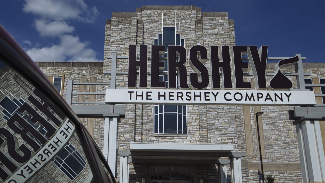 Signage is reflected in vehicle parked outside Hershey&#039;s headquarters in Hershey, Pennsylvania, U.S., on Friday, July 13, 2018.