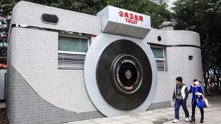 Two citizens watch a camera-shaped public toilet in Shiqiaopu Street on February 7, 2014 in Chonqging, China