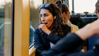 A woman stifles a yawn as she looks out of the window during her commute