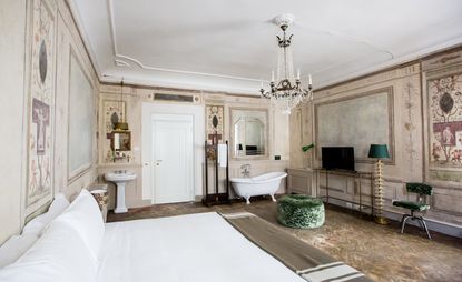 Bedroom featuring parquet flooring, chandelier, and period wallpaper