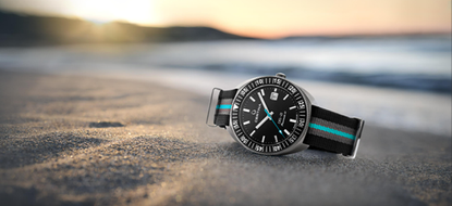 The Certina DS-2 Turning Bezel Sea Turtle Conservancy limited edition on a blue and grey NATO strap, lying on a beach